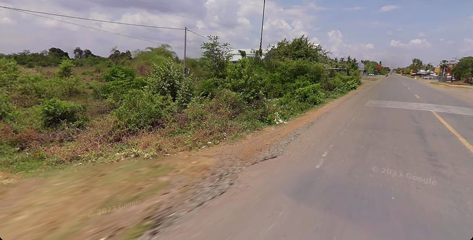 Street-level view of the 26.29-hectare industrial land for sale on National Road 44, Samrong Tong District, Kampong Speu Province, Cambodia, looking toward Phnom Penh